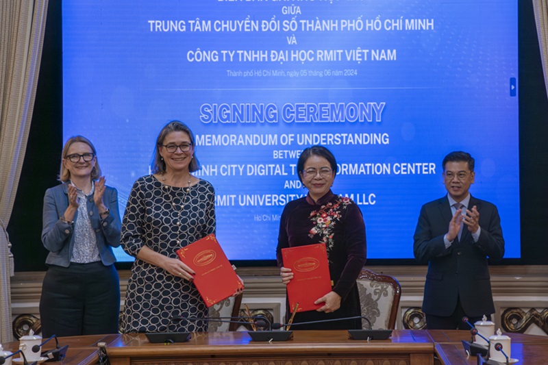 Leaders from RMIT and DXCENTER hold the MoU documents