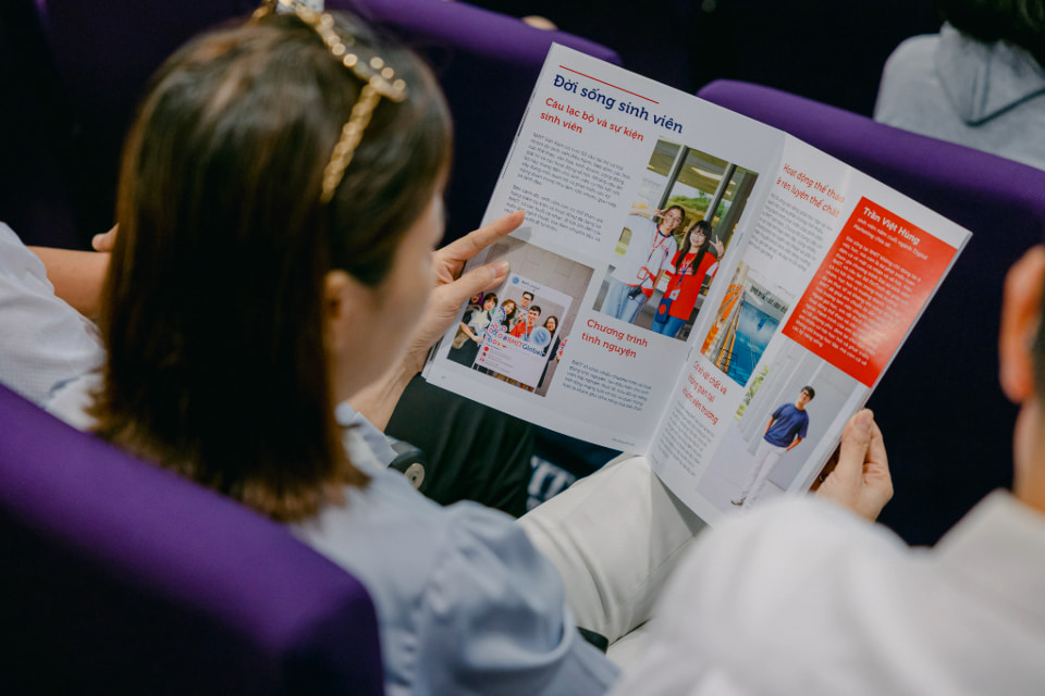 Photo of a parent reading RMIT magazine in Vietnamese