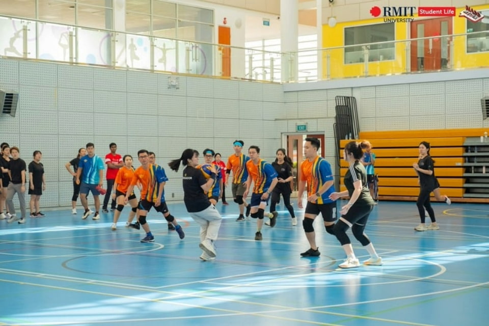 a group of students playing dodge ball on the indoor gym court at RMIT Saigon South campus