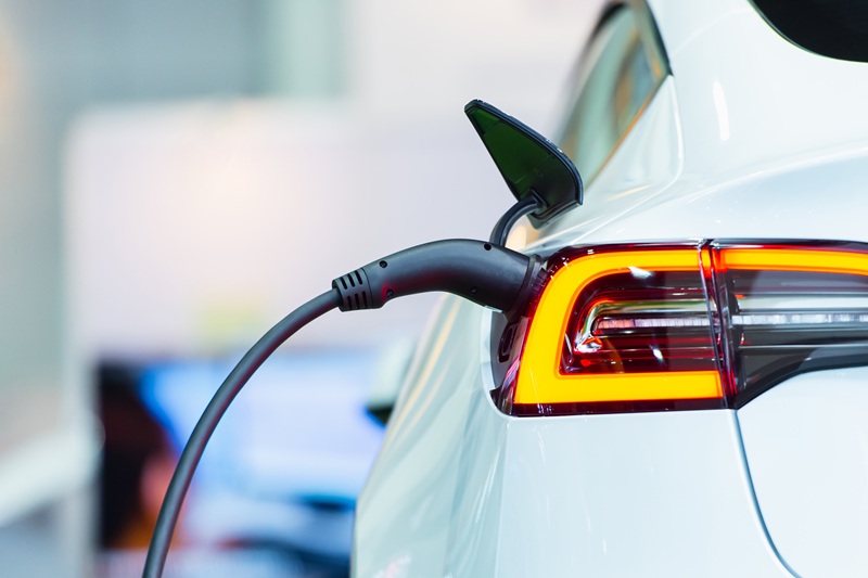 Close up of the Hybrid car electric charger station with power supply plugged into an electric car being charged.