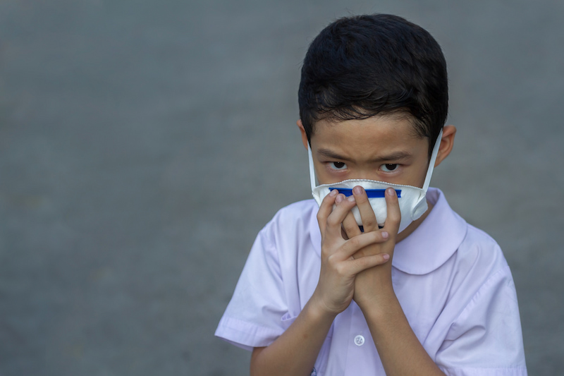 Boy wearing a face mask and frowning at the camera