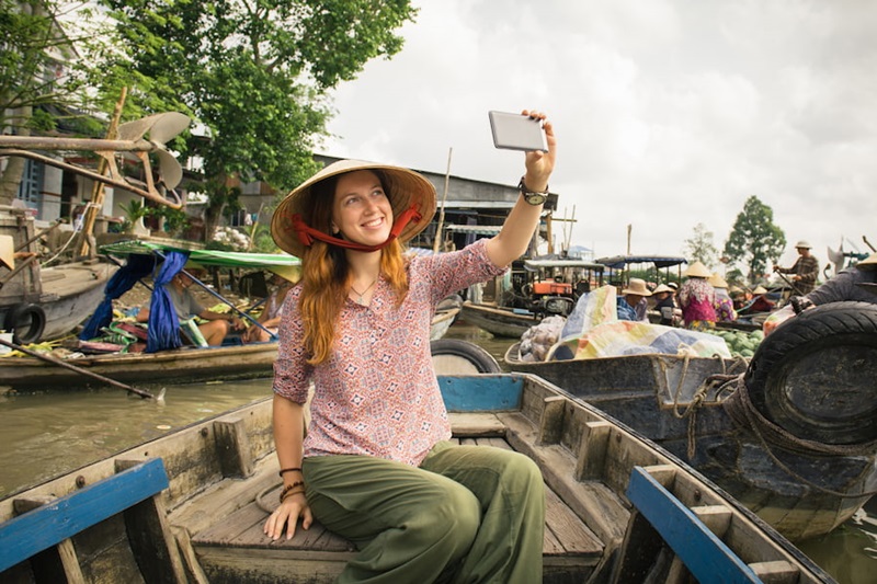 Caucasian tourist pose for a selfie on a boat