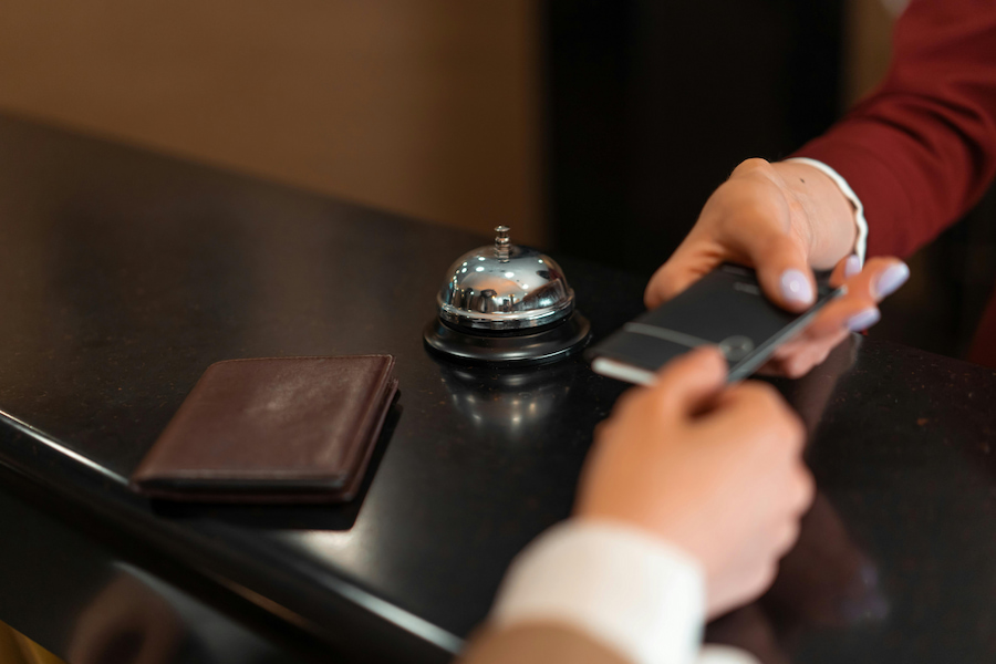 Hotel staff hands key card to guest