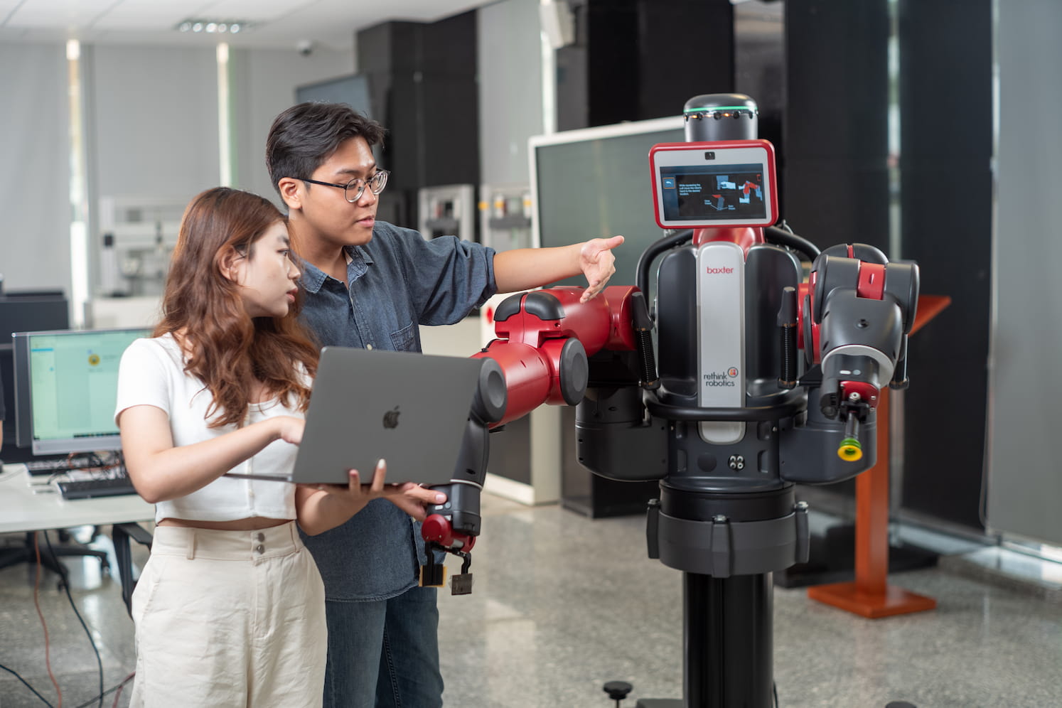 students pointing at a robot