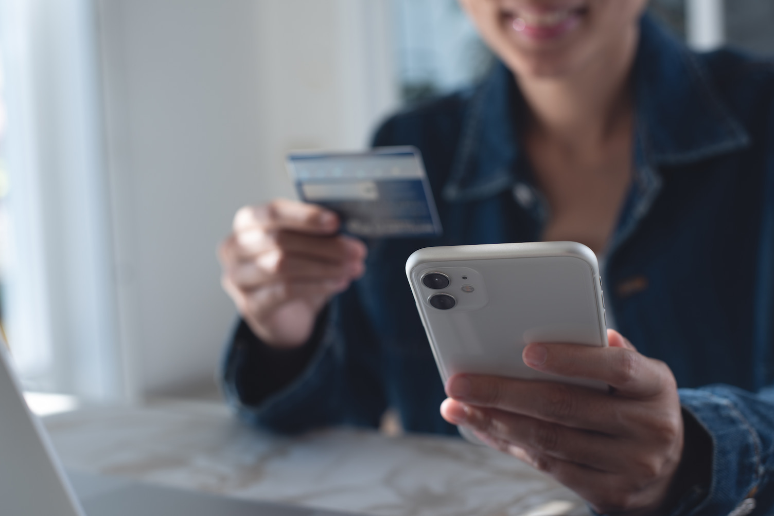 Woman holding a smartphone and bank card