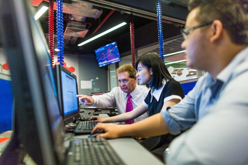 Three people looking at computers