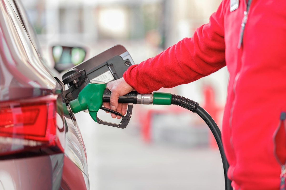 Person filling gas tank in car