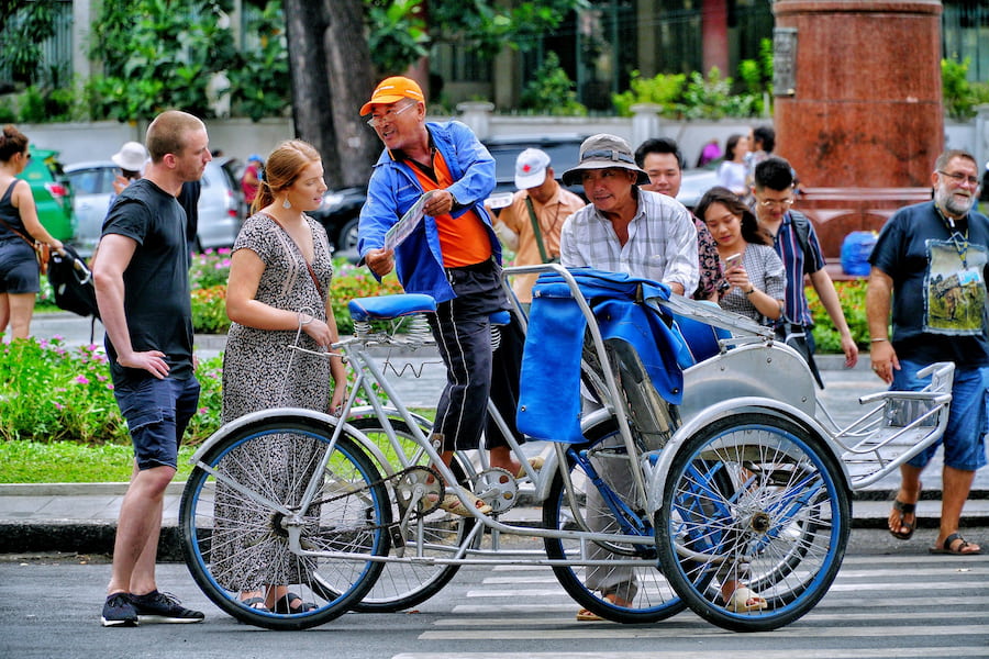 Foreign tourists talk with Vietnamese cyclo driver