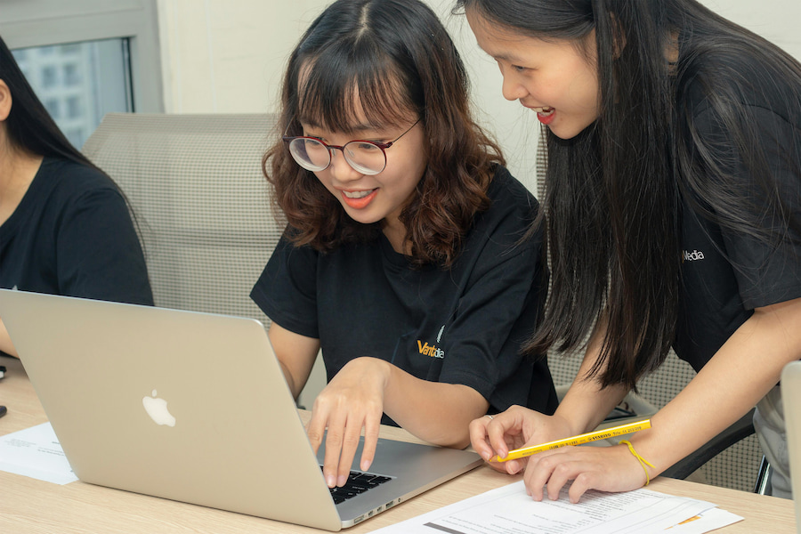 Two women look at a laptop