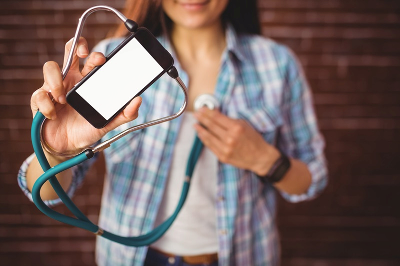 Woman holds stethoscope attached to a smartphone