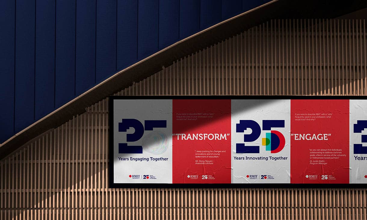 a render of the 25th anniversary animated logos as stills, showcased as A1 posters in an outdoor setting, with a black frame against some wooden slats. There is a blue fabricated wall cladding above. 