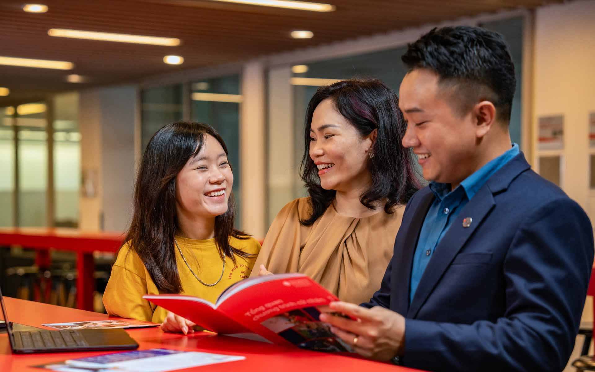 a female student and her mother talking with a lecturer at campus