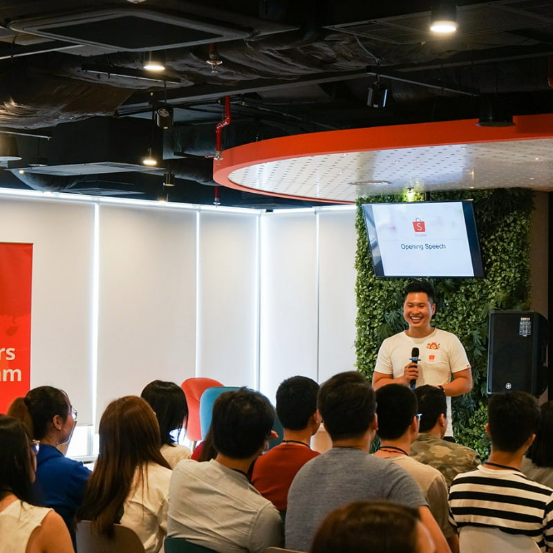 Shopee representative smiling towards a crowd of students