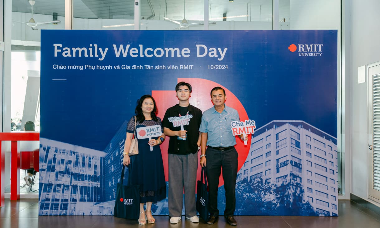 Photo of a student with his parents holding RMIT signages at Saigon South campus